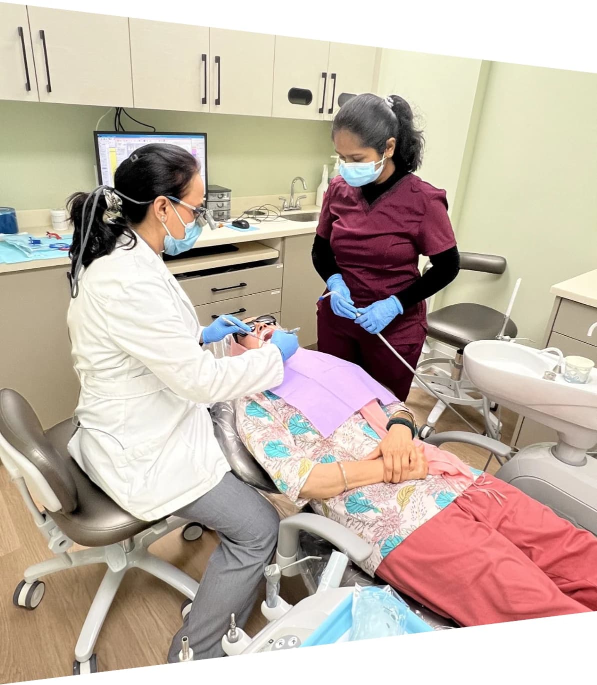 Dentist and assistant caring for a patient in a bright modern dental office